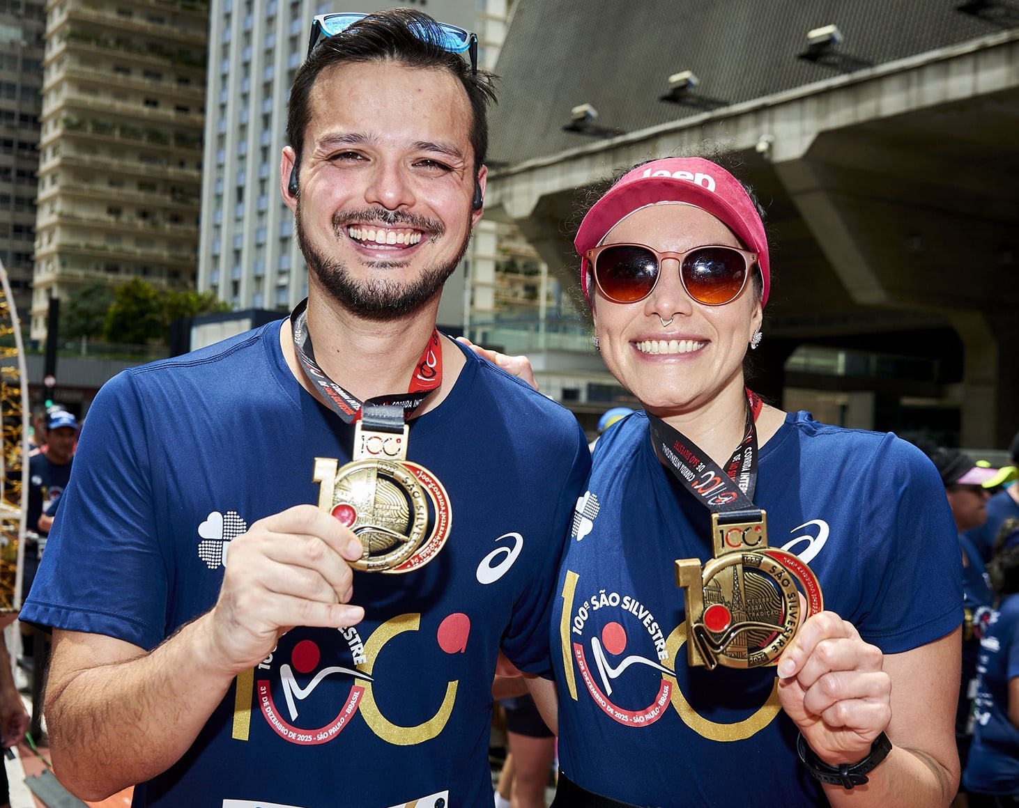 Casal exibindo as medalhas de finisher da São Silvestre