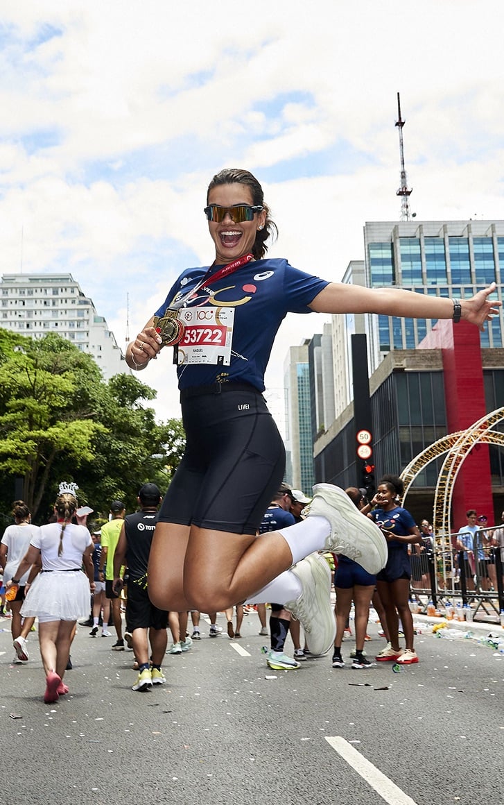 Corredora saltando de alegria com a medalha da São Silvestre